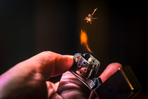 A closeup of a Zippo lighter on a dark background