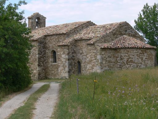 A beautiful shot of an old building and a road in the field  on a cloudy day