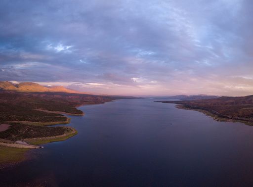An aerial view of the Lake Roosevelt and the forested areas near the shore under the cloudy sky