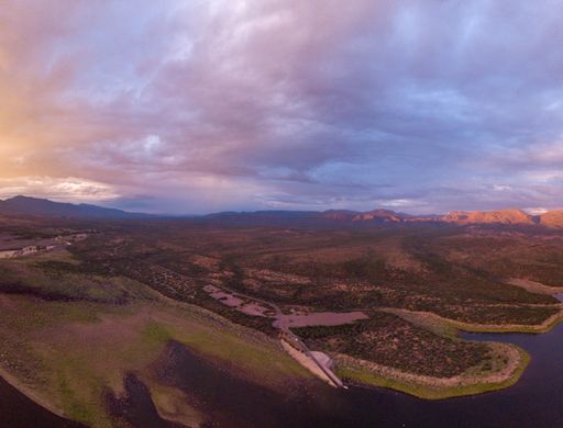 An aerial view of the Lake Roosevelt and the forested areas near the shore under the cloudy sky