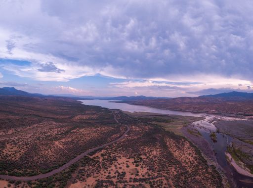 An aerial view of the Lake Roosevelt and the forested areas near the shore under the cloudy sky