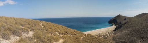 A panoramic shot of the Playa de los Muertos surrounded by the sea under the sunlight in Spain