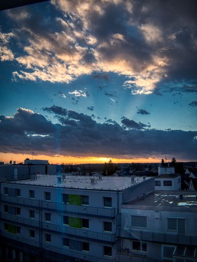 A vertical shot of a bright sunset in the cloudy sky