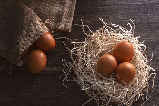 Eggs in the nest . On the wooden table. Healthy food.