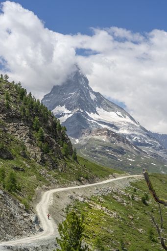 active senior woman, riding her electric mountainbike below the famous Matterhorn in Zermatt, Wallis,Switzerland