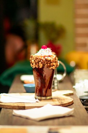 A vertical shot of a gourmet ice cream sundae on a cafe table