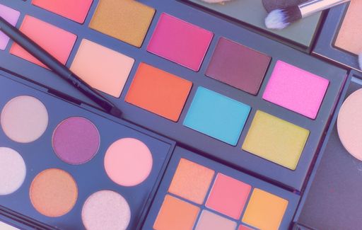 A closeup shot of colorful eyeshadow palettes and brushes