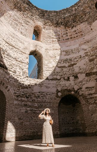 a vertical shot of Young woman standing in the vestibule inside diocletian's palace in Split, Croatia.