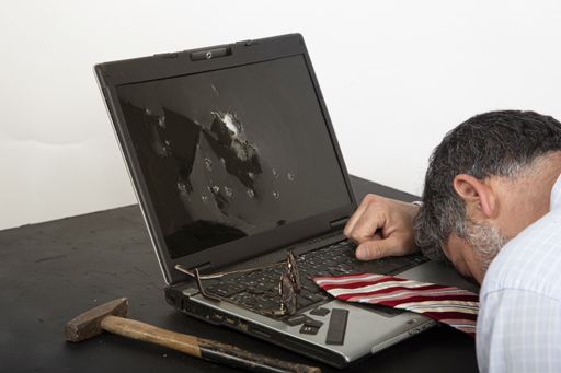 A closeup shot of a middle-aged male sleeping on a broken laptop keyboard near a hummer