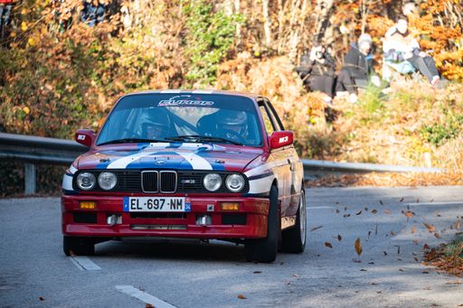 A red BMW E30 M3 rally car driving during the 69th Rally Costa Brava competition