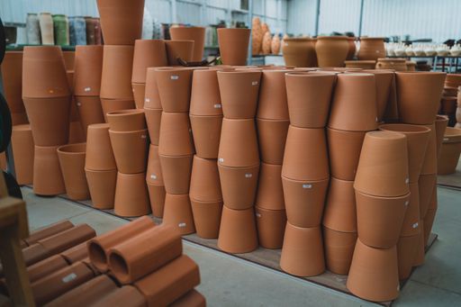 A pile of clay flowerpots stacked on each other in the warehouse