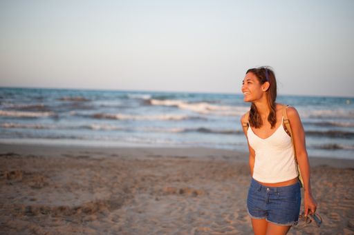 A closeup shot of a Caucasian woman walking near the sea