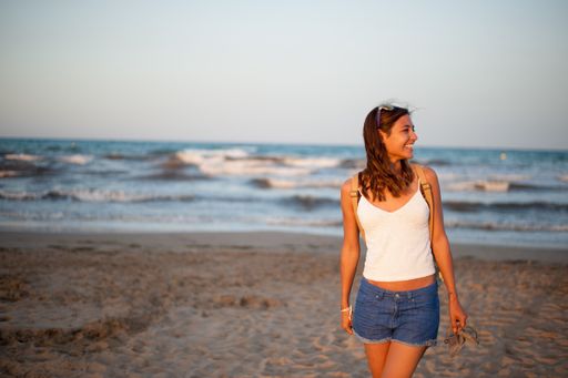 A closeup shot of a Caucasian woman walking near the sea