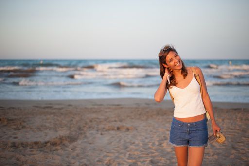 A closeup shot of a Caucasian woman walking near the sea