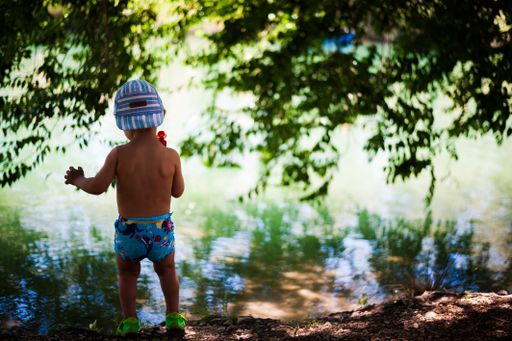Little preschool caucasian child preparing to swim in the lake
