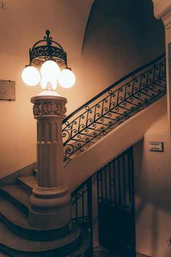 A vertical shot of a staircase in a modern building with a lamp on it