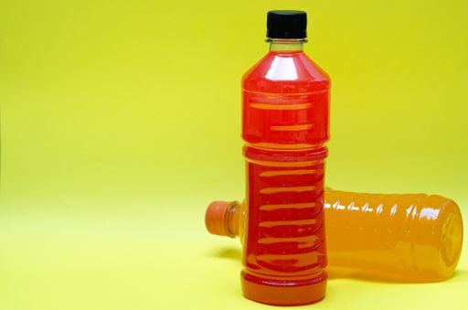 A closeup of colorful Electric Energy Drink bottles isolated on a yellow background with a copy space