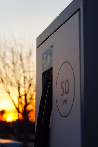 A charging station for electric cars against the sunset in the car park of a supermarket. May the sun charge our cars.