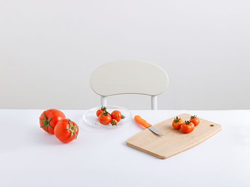 A view of tomatoes with vegetable cutting board and knife on the table