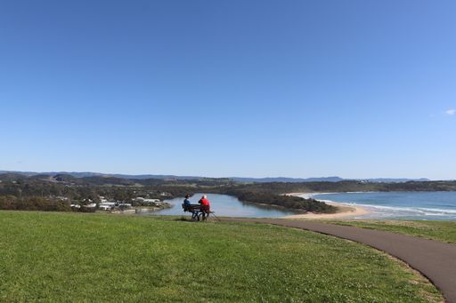 A scenic view of 2 elderly men sitting down in front of a seascape in New South Wales, Australia