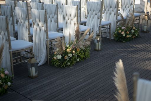A shot of decorated white chairs for a wedding reception in the evening