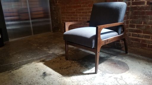 A shot of a chair inside the building in front of a stone wall
