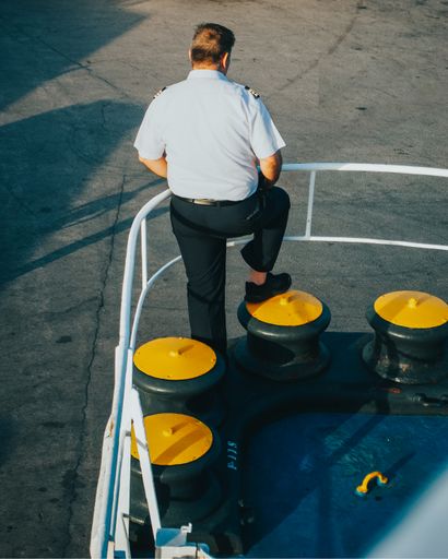 A back view of a seaman in the docked sea looking away