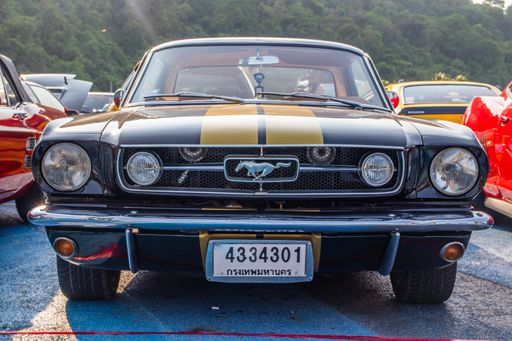 the front of a classic sports car in the area of a parking lot parking lot