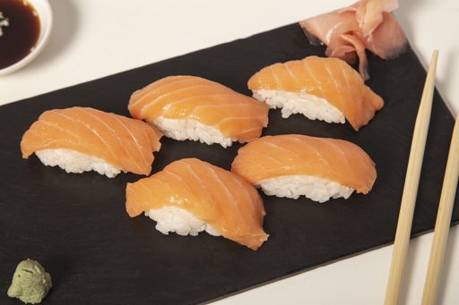 Several pieces of sushi next to each other on a black surface