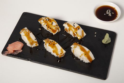 Several pieces of sushi next to each other on a black surface