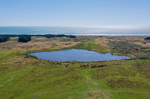 Lake waiorongomai, a small dune lake north of Otaki on the Kapiti coast of New Zealand. The Tasman Sea glistens in the afternoon sun