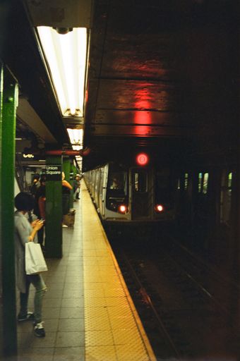 A vertical shot of the Union Square metro station with people waiting and the train arriving