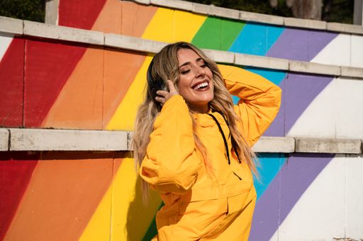 A Portrait of a cheerful woman with a skateboard on colorful stairs