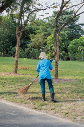 A vertical shot of a street cleaner sweeping the grass