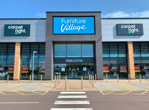 The shopfront of Furniture Village, Britain's leading independent furniture retailer, featuring a Carpet Right concession in Chelmsford, Essex, UK.