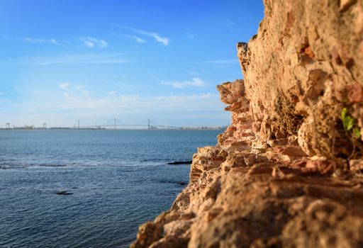 A scenic view of a bumpy cliff and a blue sea under the clear sky