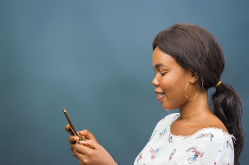 A closeup shot of a beautiful young African lady using her phone