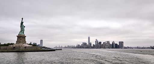A panoramic shot of the amazing Statue of Liberty on New York city background