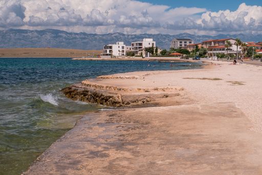 A beautiful shot of the coast and cityscape of Vir with nice view of the Adriatic sea against blue sky on a sunny day in Vir, Croatia