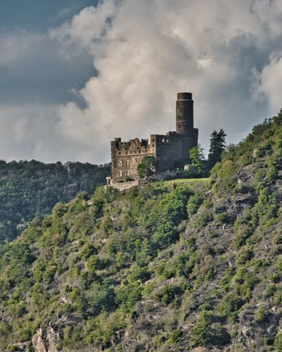 A Beautiful view of Maus castle on the top of a forested mountain