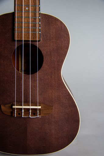 A closeup of an Ukelele with a gray background