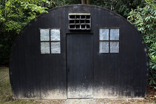 A closeup of a black wooden hut located in rural area