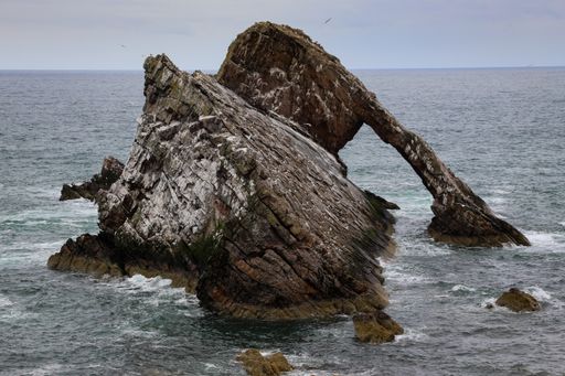 A beautiful shot of a large rock formation in the sea (Bow Fiddle Rock),Scotland, UK