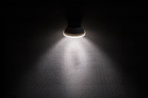 Blank concrete wall illuminated by a modern wall lamp. Closeup photo with copy space. HD high resolution for back