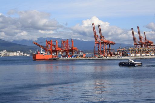The SeaBus ferry crossing Vancouver harbour with a port cranes and mountains in the background