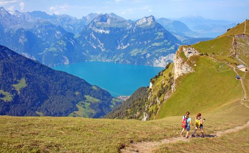Hikers on the ridge walk along Lake Lucerne near Stoos, Switzerland, between Klingenstock and Fronalpstock  with impressive views on the Alps.