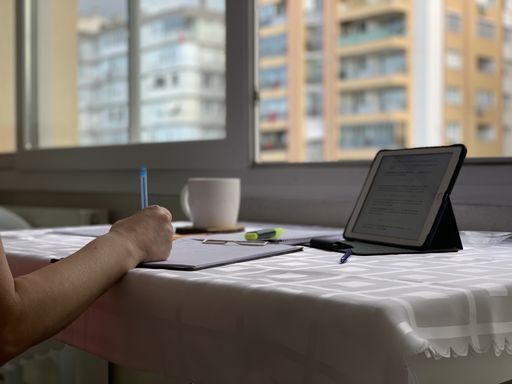A selective focus shot of a female student making notes from a tablet - concept of education