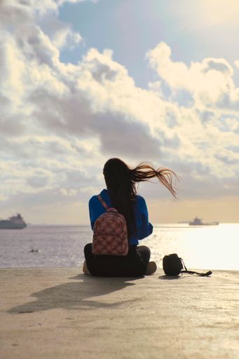 A Young Girl looking at the sunset in the bay