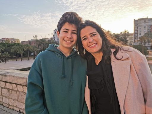 Beautiful mother and teenage son posing happily for a family portrait outdoors