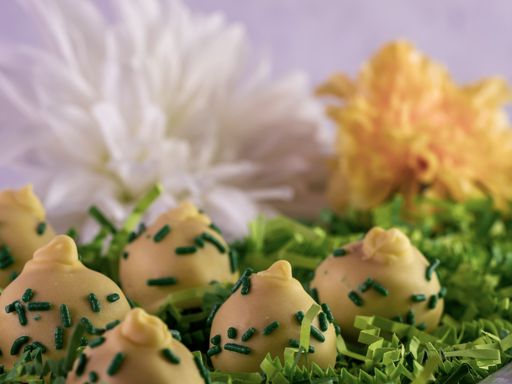 A closeup shot of white chocolates with green sprinkles isolated on a white background